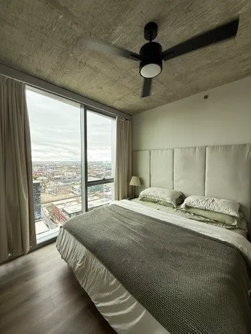 a bedroom with a bed and a large window