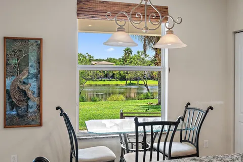 a living room with furniture kitchen view and a chandelier