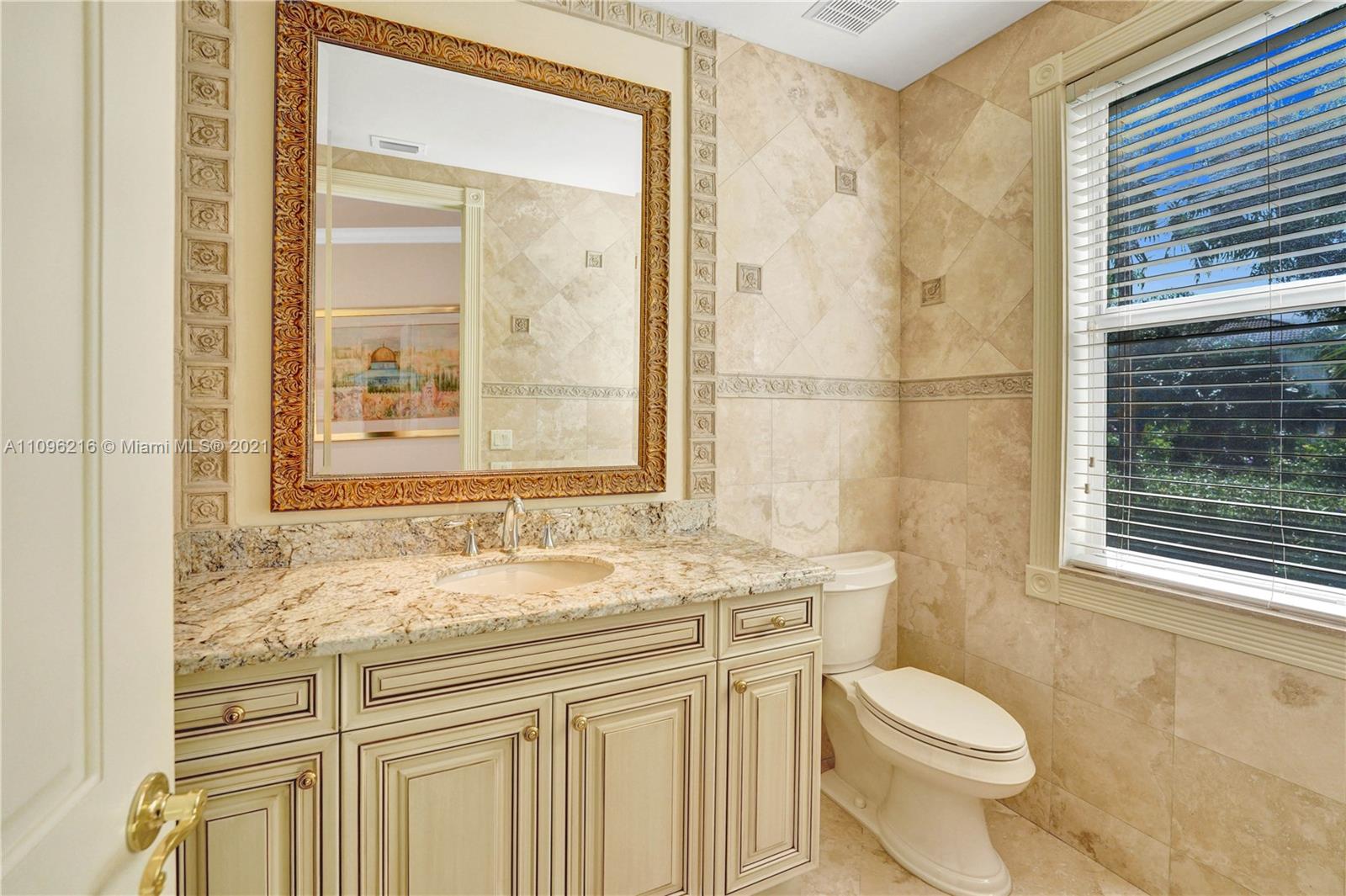 2755 Paddock Road Weston, FL 33331 - Photo 31 of 51 a bathroom with a granite countertop sink a toilet a mirror and a window