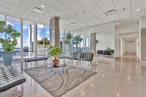 a living room with furniture a wooden floor and next to a window