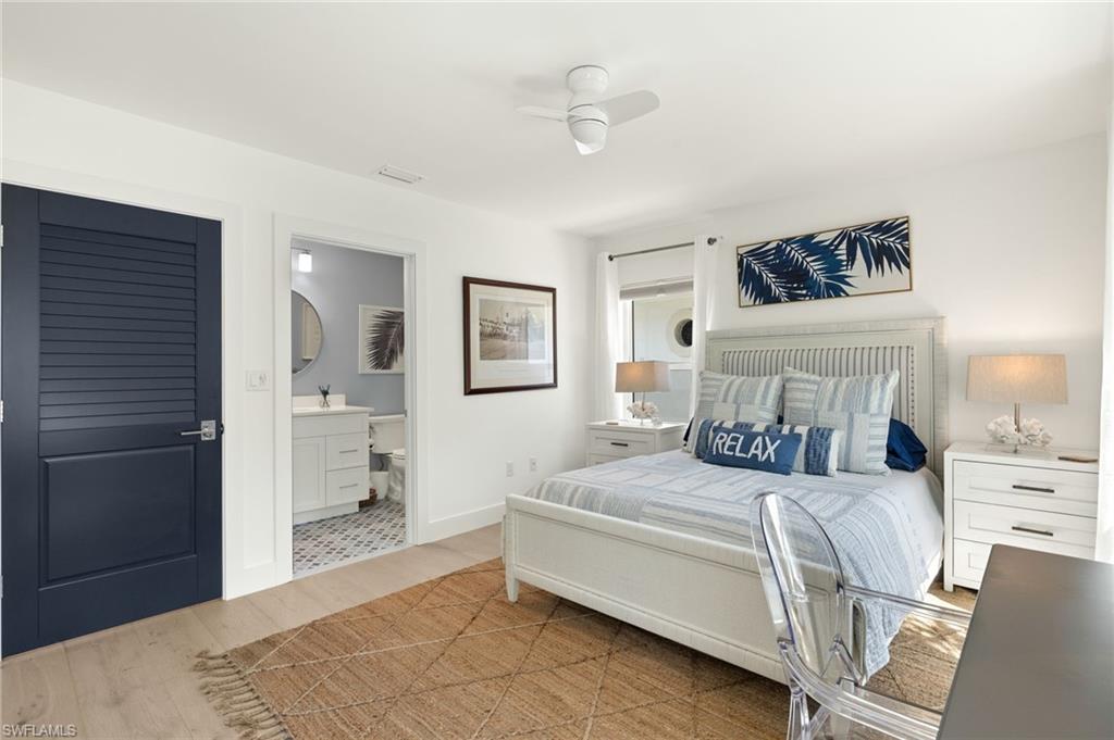 1060 6th Street South, Unit 1060 Naples, FL 34102 - Photo 20 of 26 a bedroom with a bed a mirror and lamp