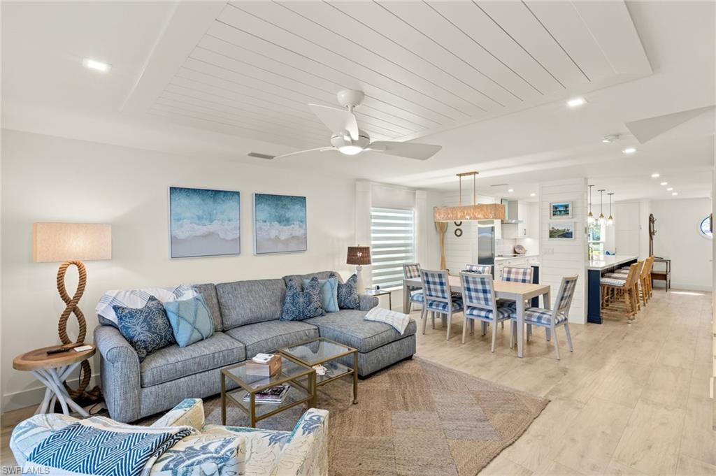 1060 6th Street South, Unit 1060 Naples, FL 34102 - Photo 2 of 26 a living room with furniture dining table a chandelier and a dining table