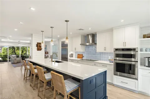 a kitchen with a table chairs sink and cabinets