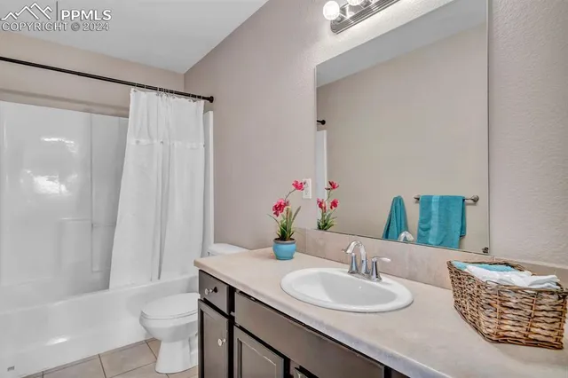 a bathroom with a granite countertop sink a toilet and a large mirror
