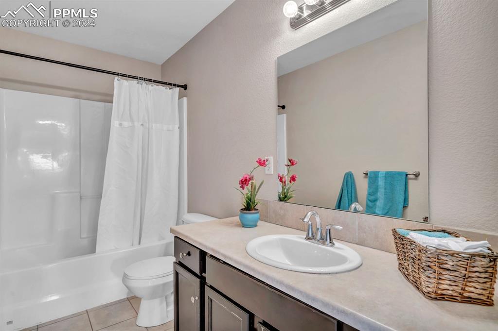 861 Circle Road Palmer Lake, CO 80133 - Photo 23 of 41 a bathroom with a granite countertop sink a toilet and a large mirror