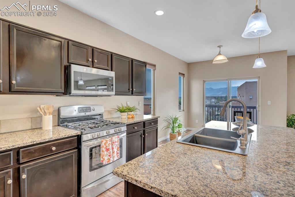 861 Circle Road Palmer Lake, CO 80133 - Photo 5 of 41 a kitchen with stainless steel appliances granite countertop a sink stove and refrigerator
