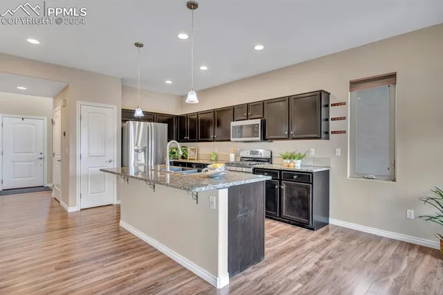 a kitchen with stainless steel appliances granite countertop a refrigerator stove and oven