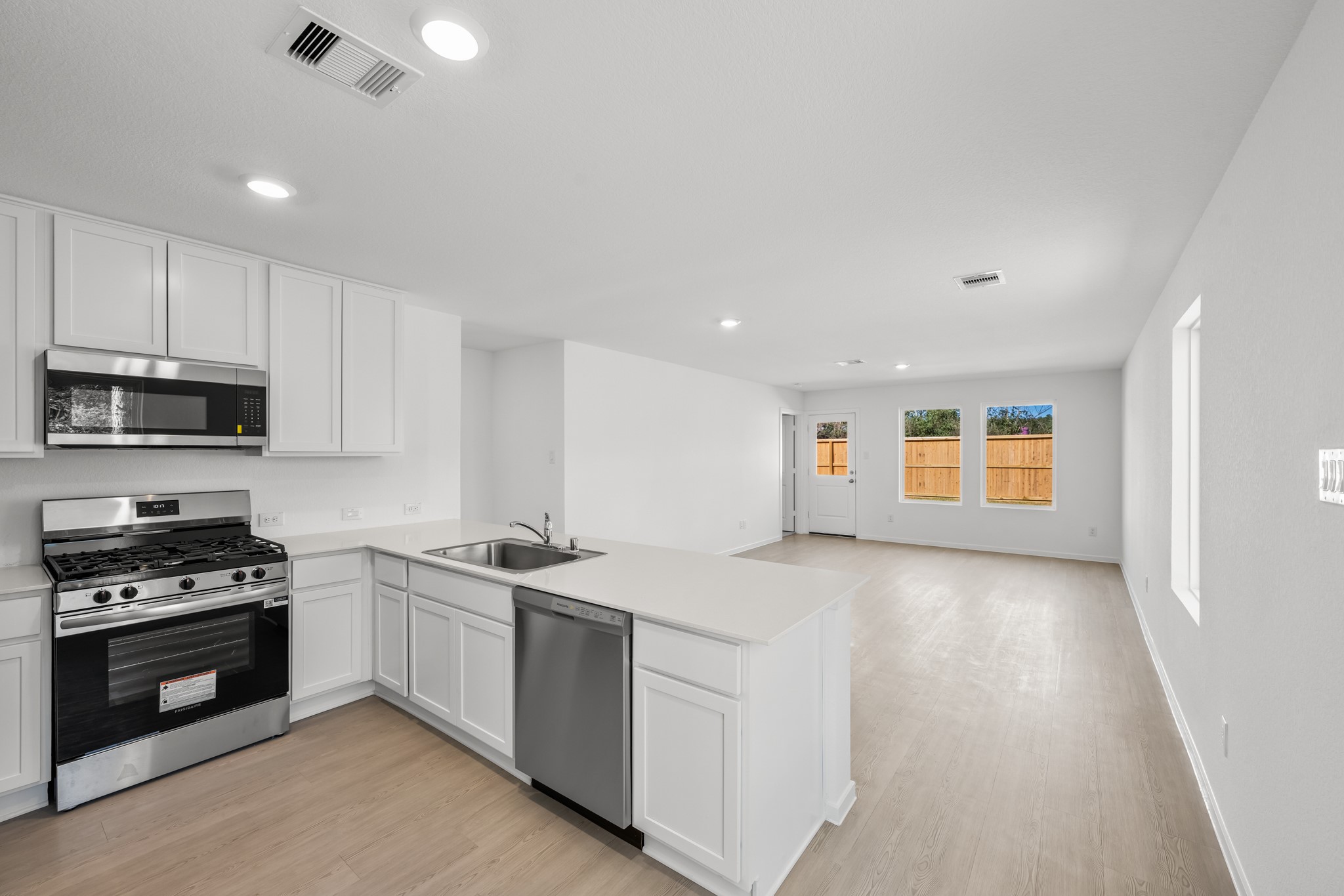 10583 Altitude Way Conroe, TX 77303 - Photo 7 of 33 a kitchen with stainless steel appliances granite countertop a stove a sink and a microwave