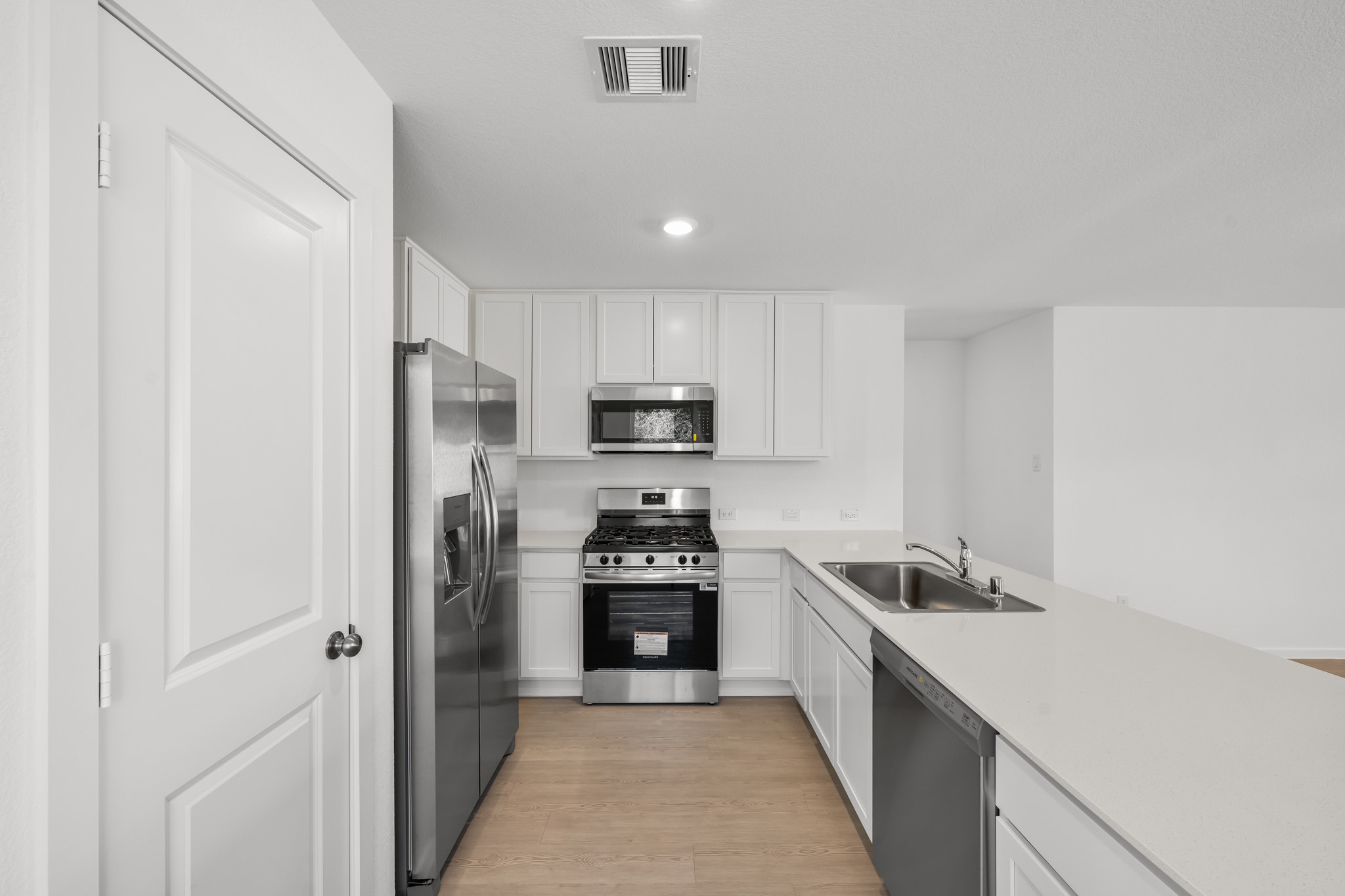 10583 Altitude Way Conroe, TX 77303 - Photo 8 of 33 a kitchen with a refrigerator a stove top oven and cabinets
