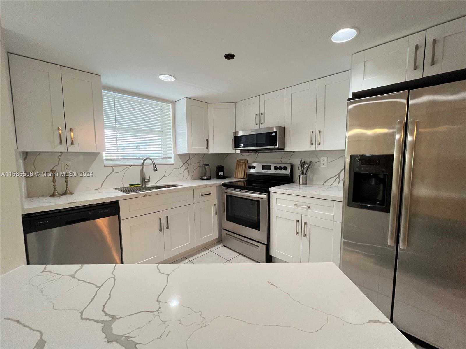 a kitchen with a refrigerator sink and cabinets
