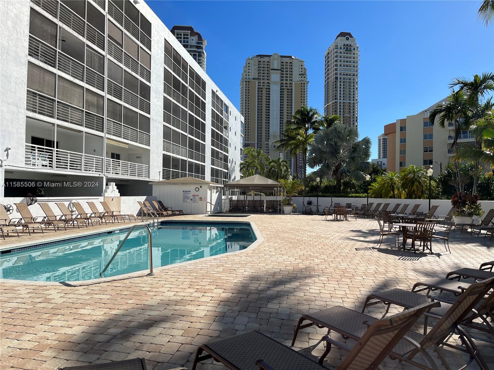 17801 North Bay Road, Unit 303 Sunny Isles Beach, FL 33160 - Photo 14 of 17 a view of a swimming pool with a lounge chairs