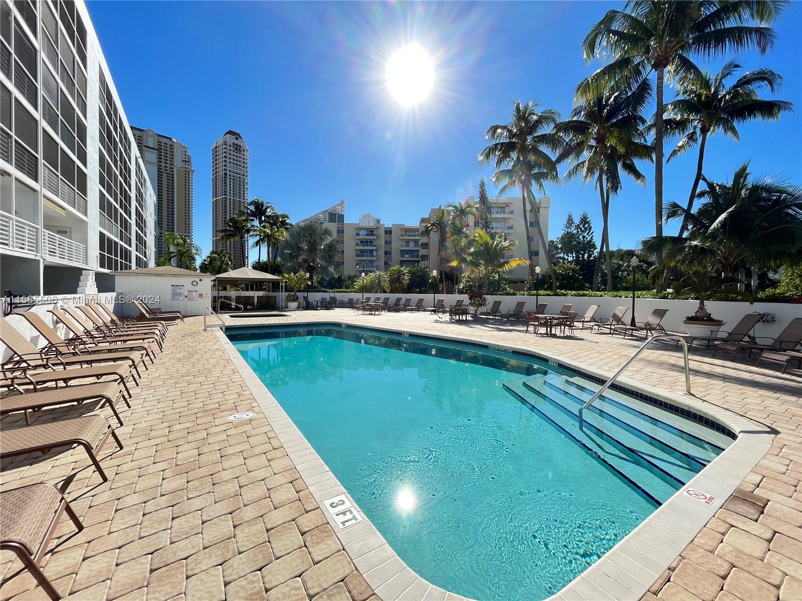 17801 North Bay Road, Unit 303 Sunny Isles Beach, FL 33160 - Photo 15 of 17 a swimming pool with outdoor seating and yard
