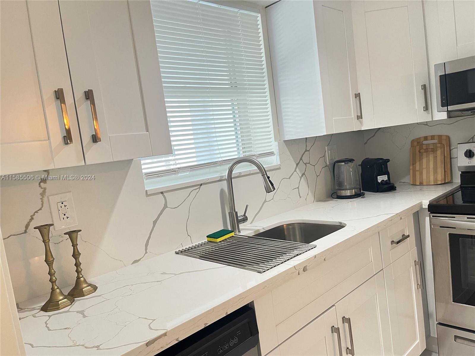 17801 North Bay Road, Unit 303 Sunny Isles Beach, FL 33160 - Photo 3 of 17 a kitchen with a sink and cabinets
