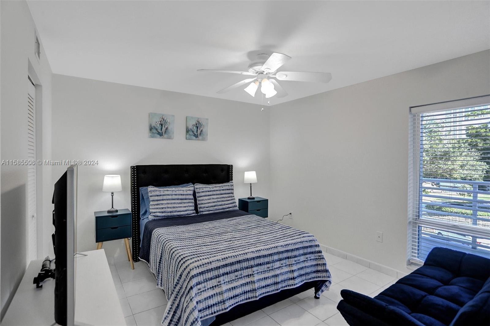 17801 North Bay Road, Unit 303 Sunny Isles Beach, FL 33160 - Photo 9 of 17 a bedroom with a bed and a chandelier