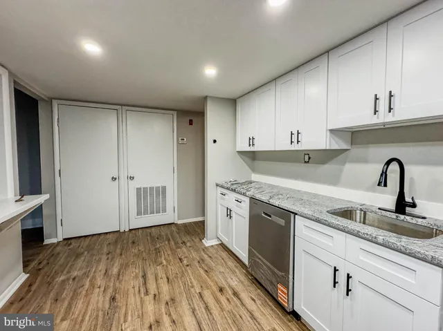 a kitchen with granite countertop white cabinets and white appliances