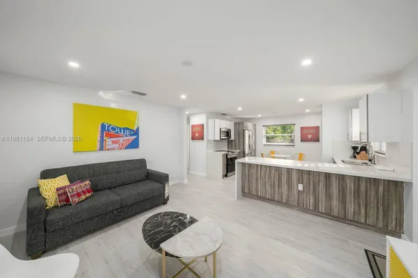 a living room with furniture and a wooden floor