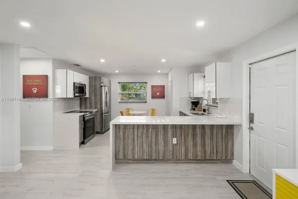 a kitchen with stainless steel appliances a refrigerator and a stove top oven