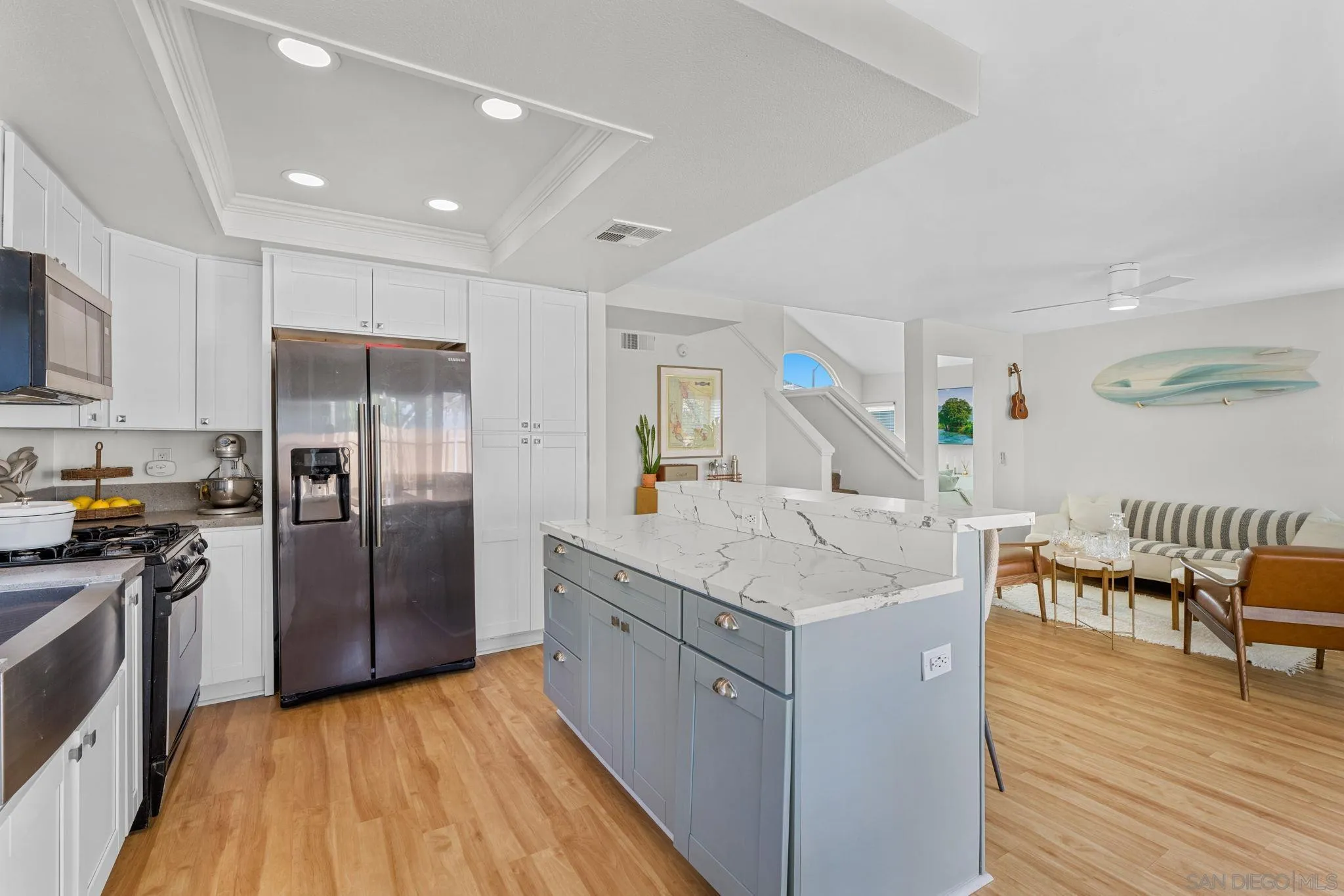 5392 Blackberry Way Oceanside, CA 92057 - Photo 20 of 37 a kitchen with stainless steel appliances granite countertop a refrigerator a stove top oven a dining table and chairs with wooden floor