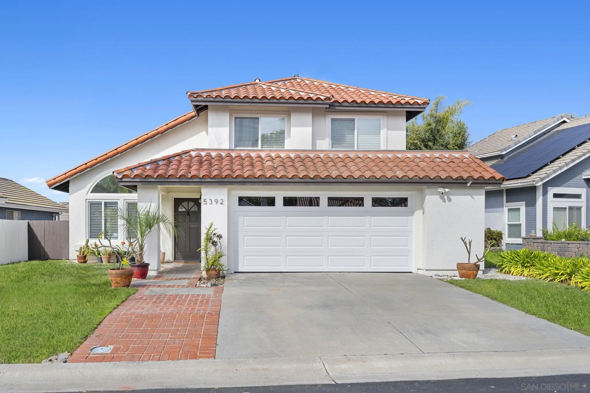 5392 Blackberry Way Oceanside, CA 92057 - Photo 2 of 37 a front view of a house with a yard and garage