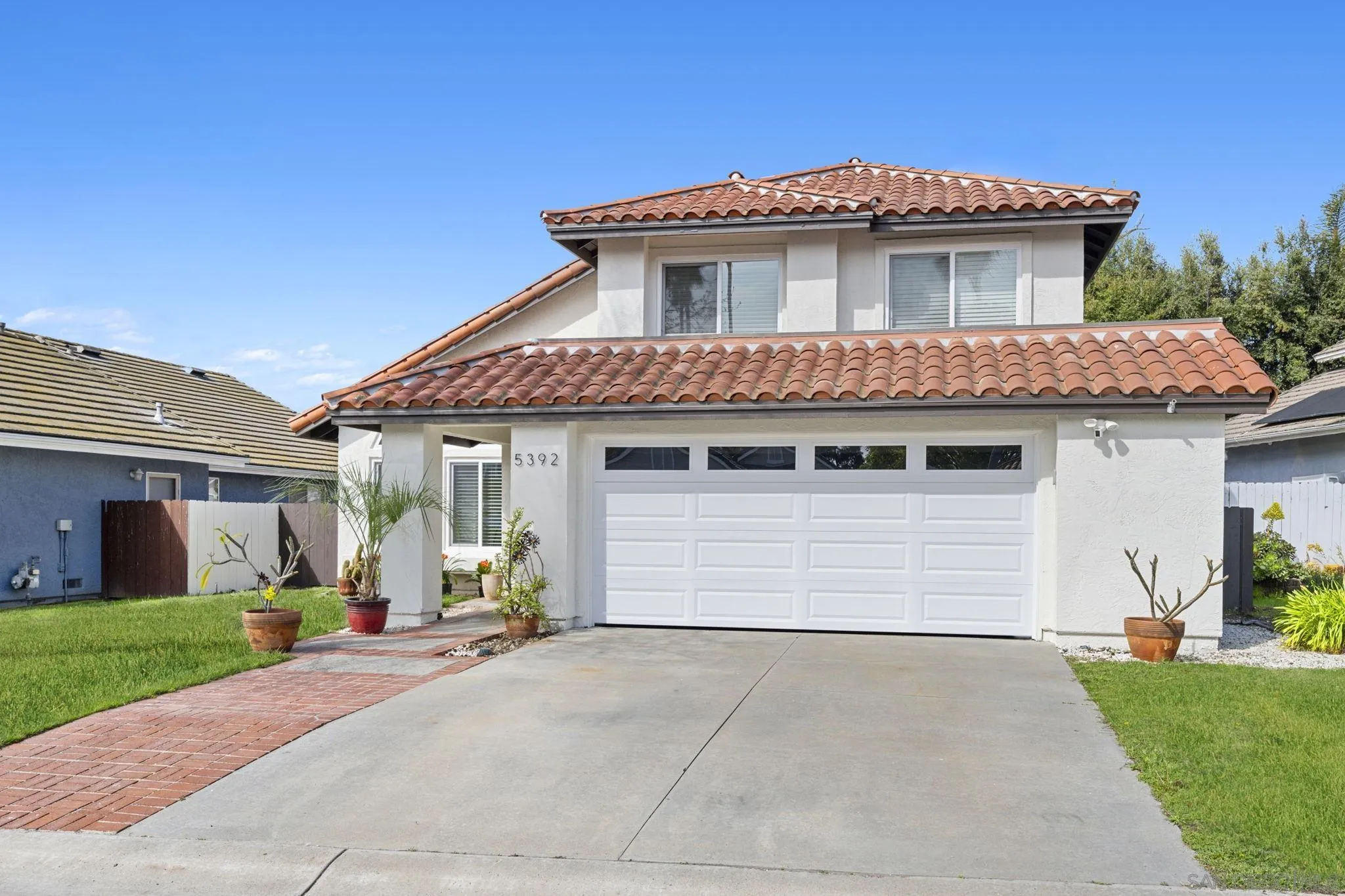 5392 Blackberry Way Oceanside, CA 92057 - Photo 3 of 37 a view of white house with a yard and garage