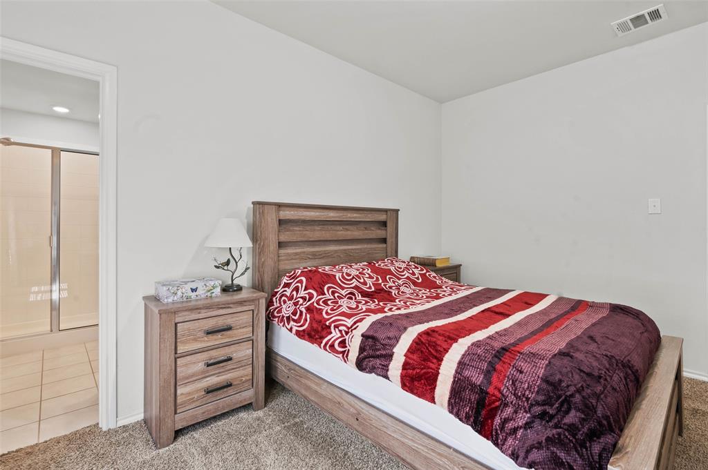 409 Wilson Way Denton, TX 76207 - Photo 14 of 33 Carpeted bedroom featuring a wooden bed frame and matching two-drawer nightstand
