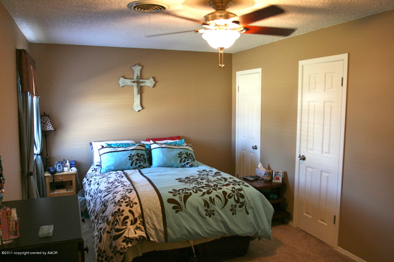 5332 Capulin Lane Amarillo, TX 79110 - Photo 4 of 10 a bedroom with a bed and a chandelier