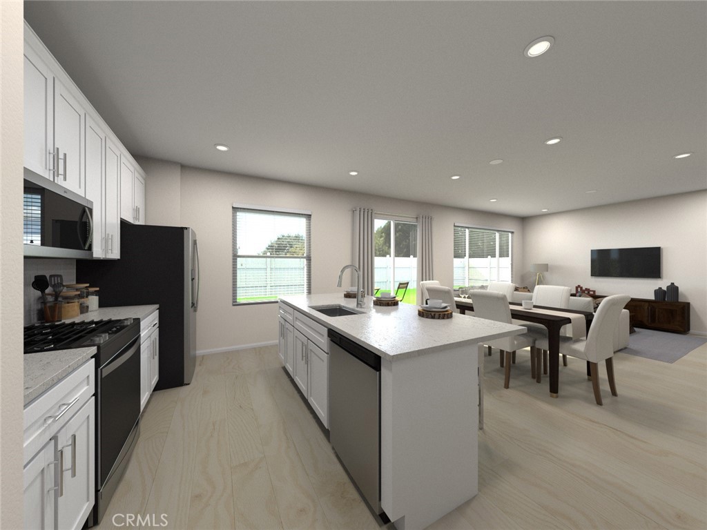 663 Joseph Privado Ontario, CA 91761 - Photo 4 of 13 a kitchen with kitchen island granite countertop a sink counter top space appliances and cabinets