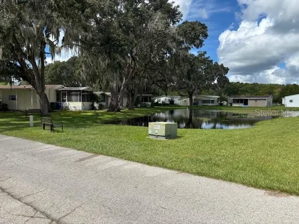 a view of a house with backyard and sitting area