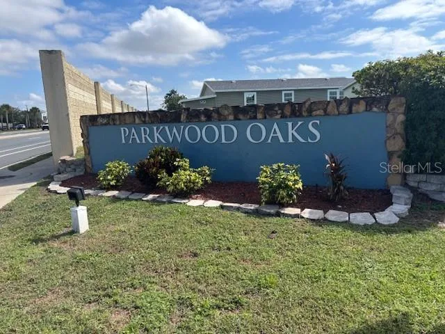 a sign that is sitting in the grass next to a building