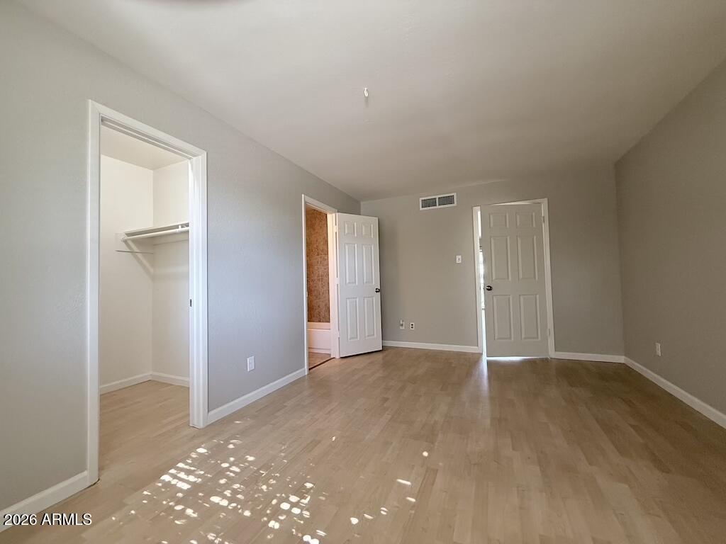 1004 East Osborn Road, Unit E Phoenix, AZ 85014 - Photo 5 of 32 a view of an empty room with wooden floor and closet