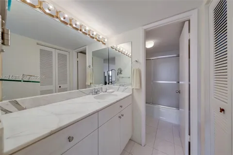 a en suite bathroom with a granite countertop sink and a mirror