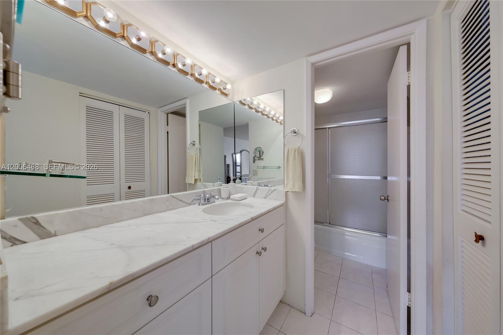 600 Northeast 36th Street, Unit 421 Miami, FL 33137 - Photo 11 of 16 a en suite bathroom with a granite countertop sink and a mirror