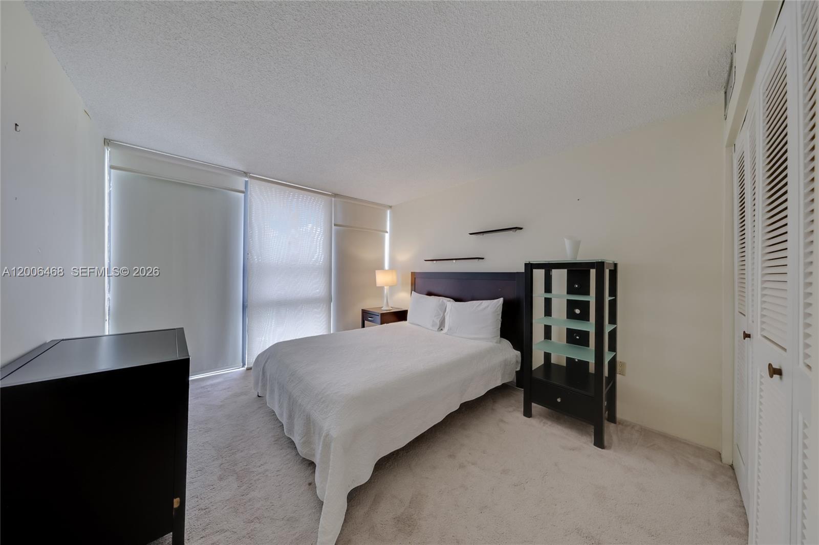 600 Northeast 36th Street, Unit 421 Miami, FL 33137 - Photo 13 of 16 a bedroom with a bed and a night stand