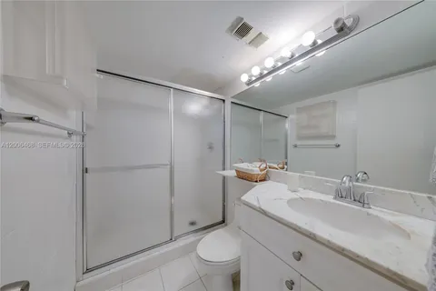 a bathroom with a granite countertop sink a toilet and a mirror