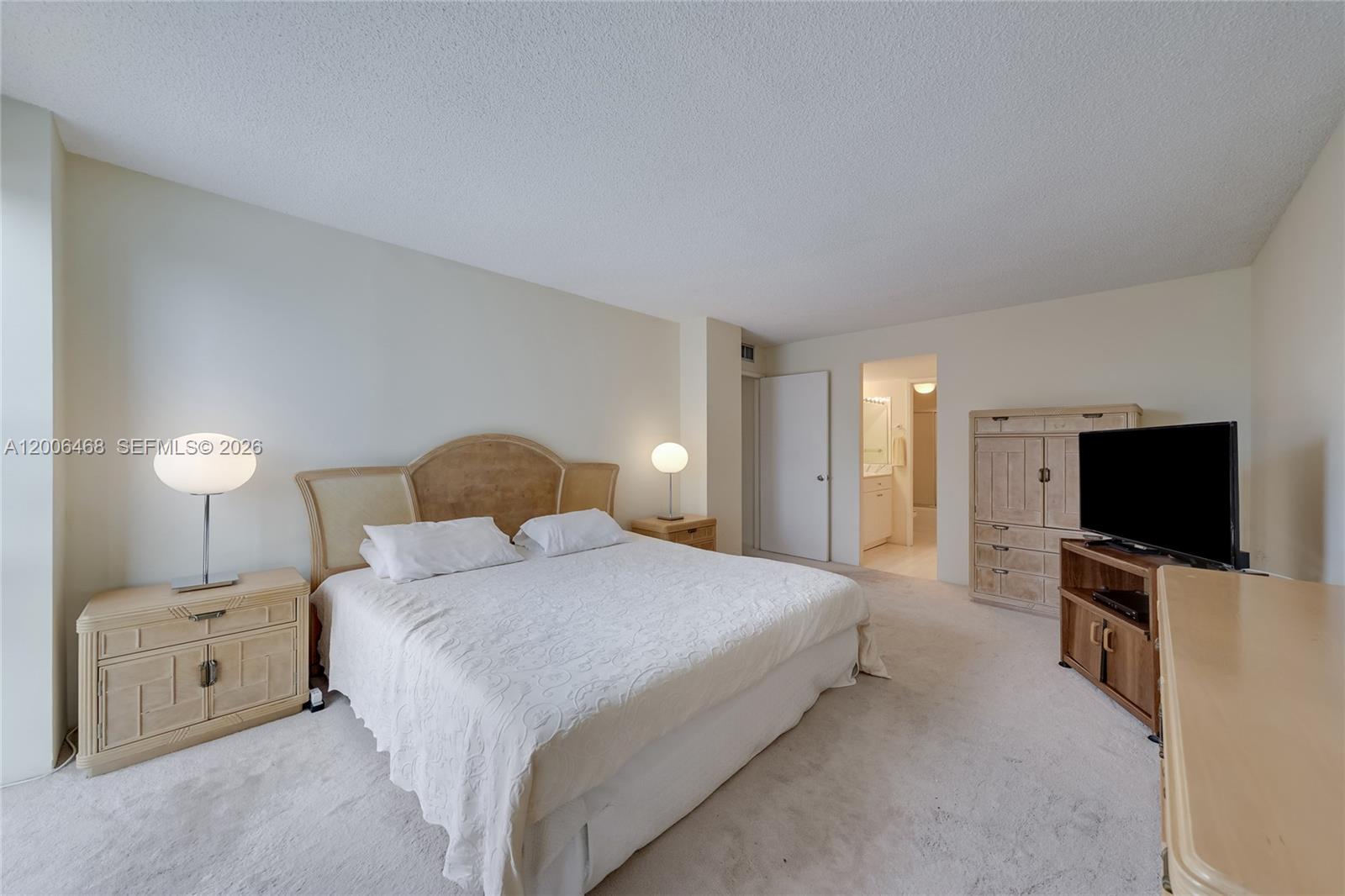 600 Northeast 36th Street, Unit 421 Miami, FL 33137 - Photo 8 of 16 a bedroom with a large bed and a flat tv screen on a dresser
