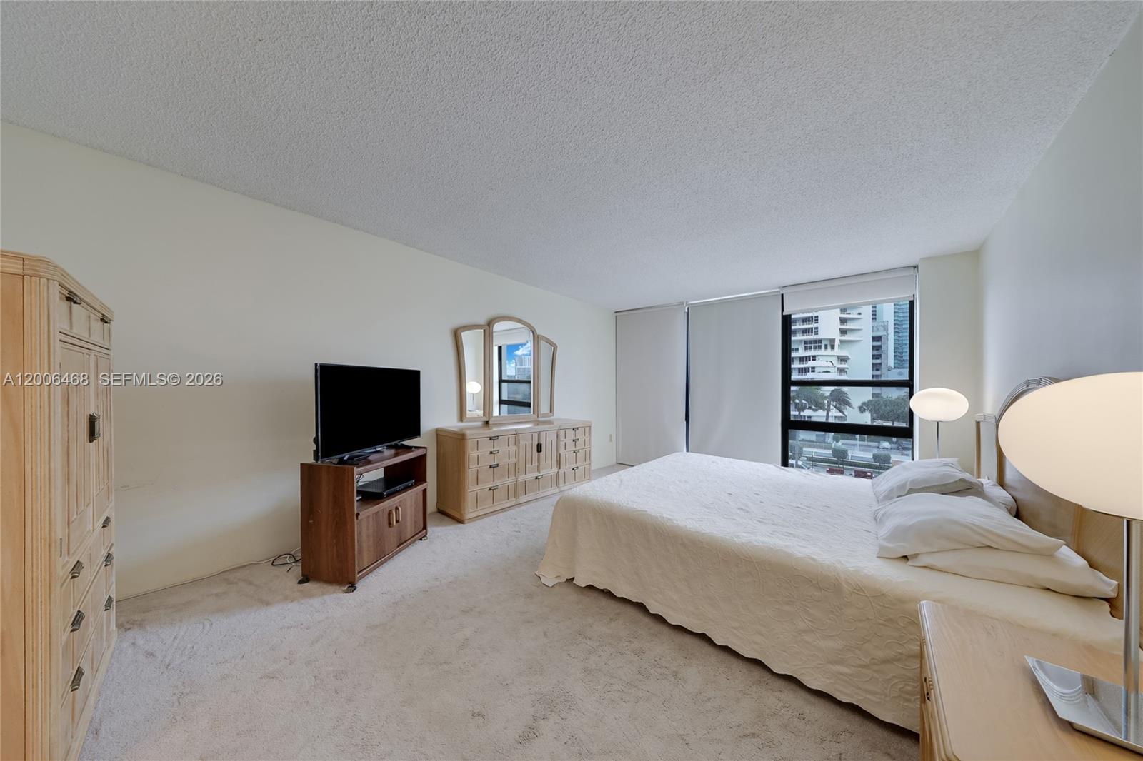 600 Northeast 36th Street, Unit 421 Miami, FL 33137 - Photo 9 of 16 a bedroom with a bed and a flat screen tv