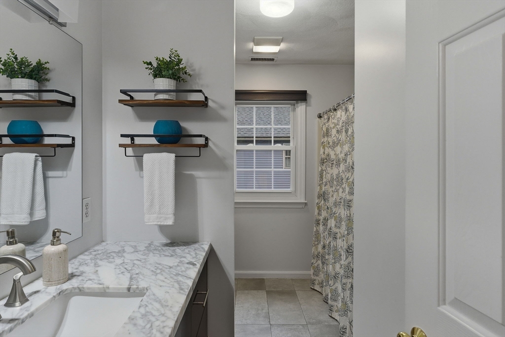 5 Aspen Circle Bedford, MA 01730 - Photo 20 of 28 a bathroom with a granite countertop sink a toilet and shower