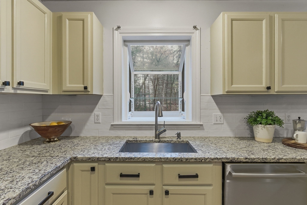 5 Aspen Circle Bedford, MA 01730 - Photo 6 of 28 a kitchen with granite countertop a sink stainless steel appliances white cabinets and a window
