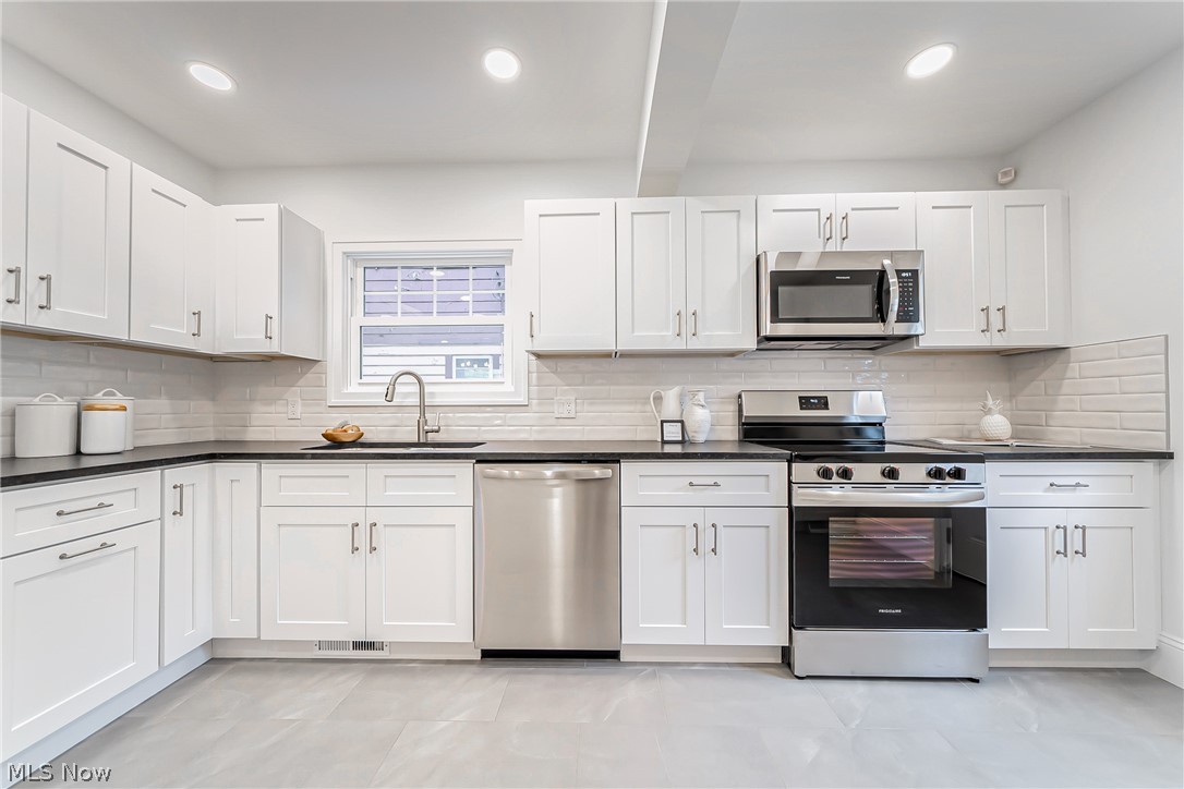3947 Rosemond Road Cleveland Heights, OH 44121 - Photo 18 of 44 Kitchen with tasteful backsplash, stainless steel appliances, light tile floors, sink, and white cabinetry