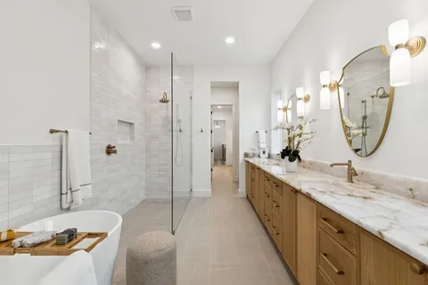a large bathroom with a granite countertop tub a double vanity sink and a mirror