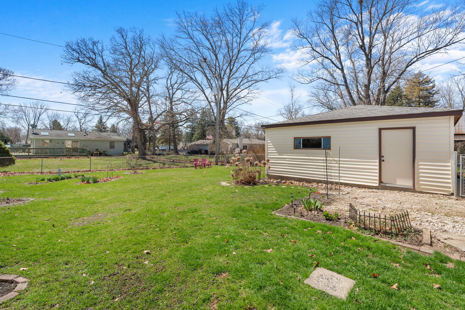 8911 Ramble Road Wonder Lake, IL 60097 - Photo 22 of 36 a backyard of a house with plants and large tree