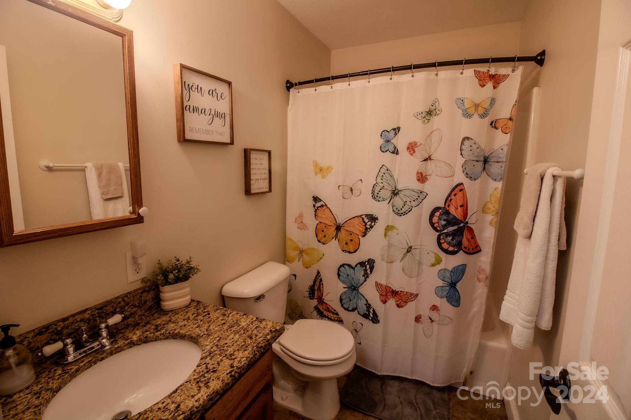 21 Norman Road Fletcher, NC 28732 - Photo 14 of 21 a bathroom with a granite countertop toilet sink and mirror