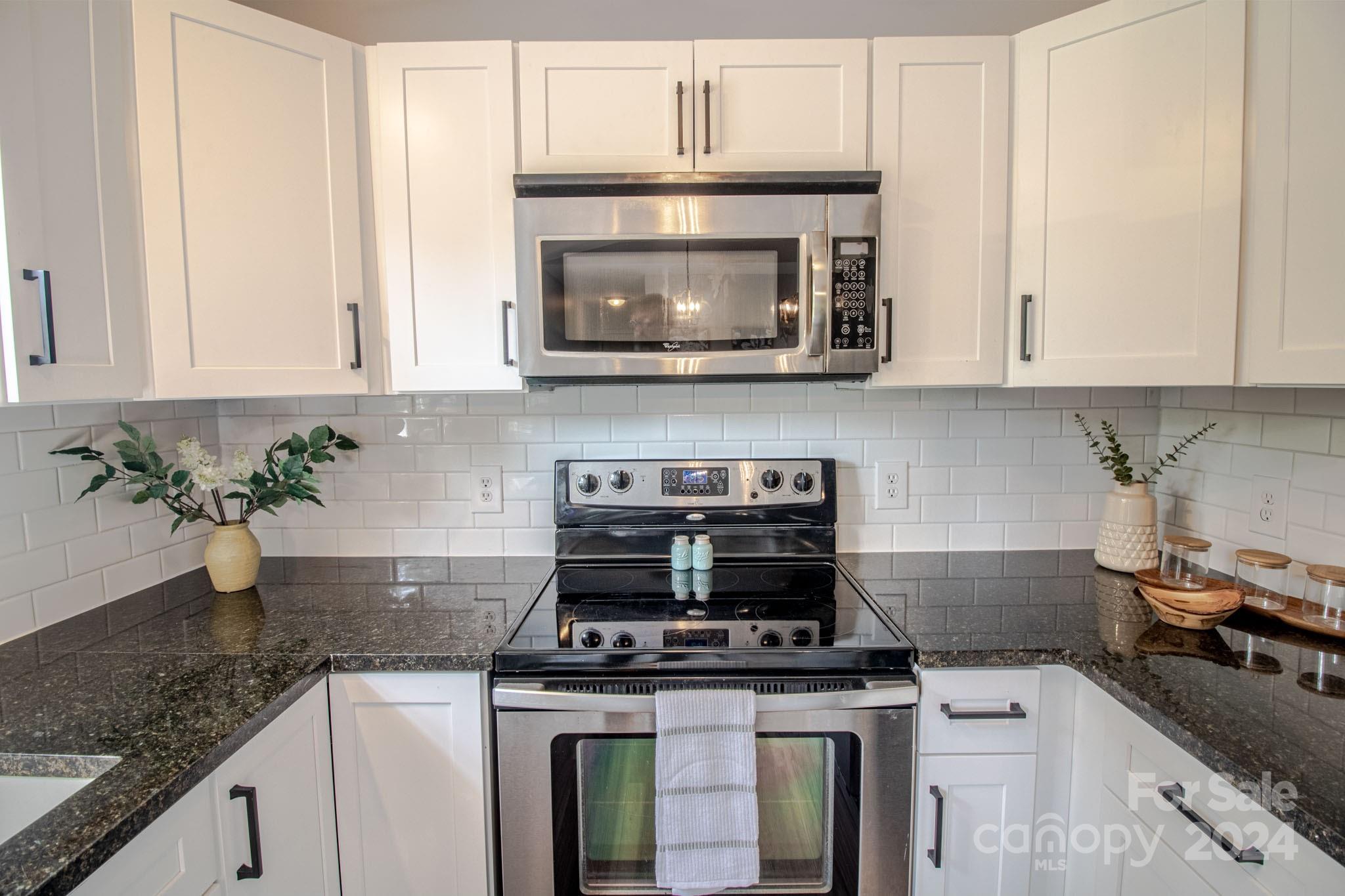 21 Norman Road Fletcher, NC 28732 - Photo 6 of 21 a kitchen with granite countertop a stove top oven cabinetry and granite counter tops