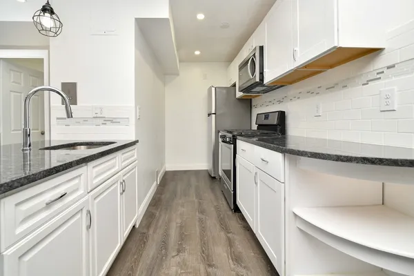 a kitchen with stainless steel appliances granite countertop a sink stove and refrigerator
