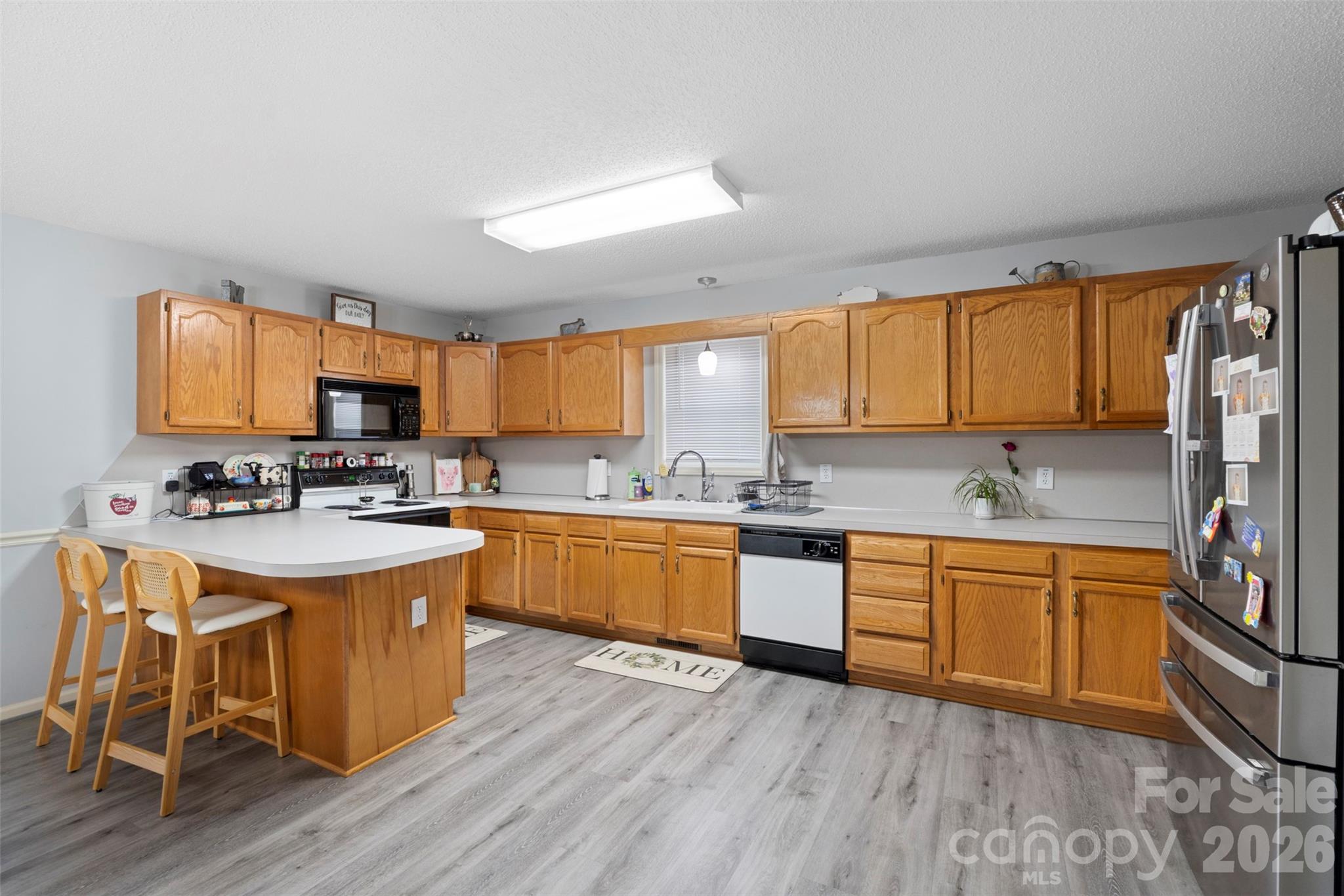 155 Sundial Street Lexington, NC 27295 - Photo 11 of 38 a kitchen with stainless steel appliances granite countertop wooden cabinets a sink dishwasher a stove and a refrigerator with wooden floor