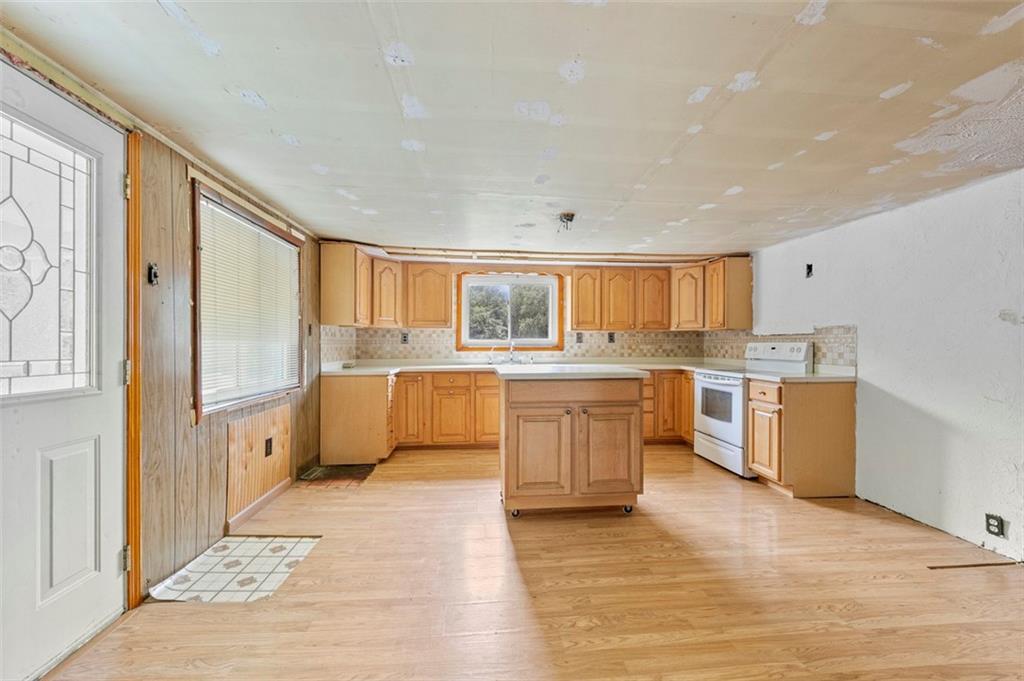 878 Bolden Road Smock, PA 15480 - Photo 12 of 23 a large kitchen with a stove a sink dishwasher a refrigerator and white cabinets with wooden floor