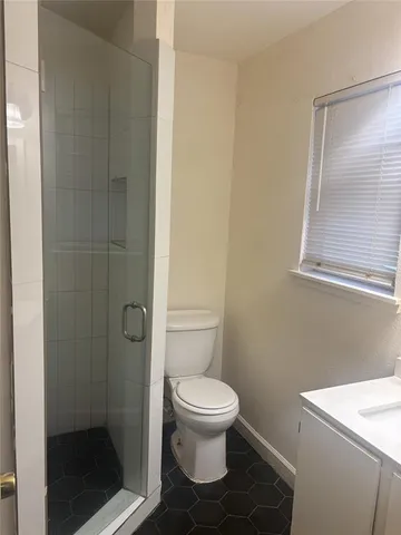 a bathroom with a toilet and a shower
