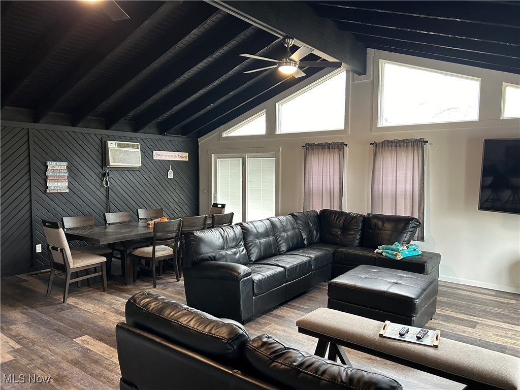 3005 Bardshar Road Sandusky, OH 44870 - Photo 9 of 24 Living room featuring a wall unit AC, a ceiling fan, wood finished floors, baseboards, and lofted ceiling with beams