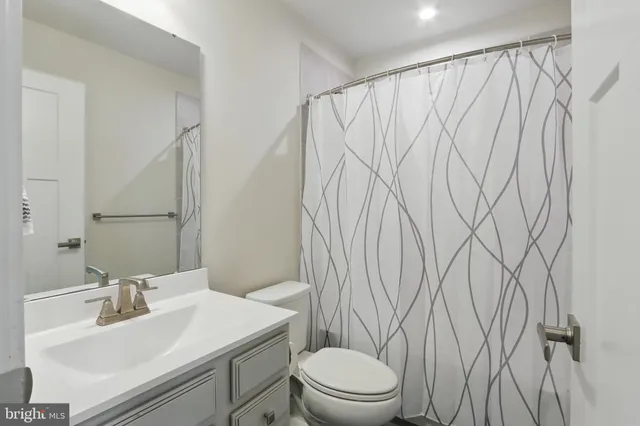 a bathroom with a sink a toilet and a mirror