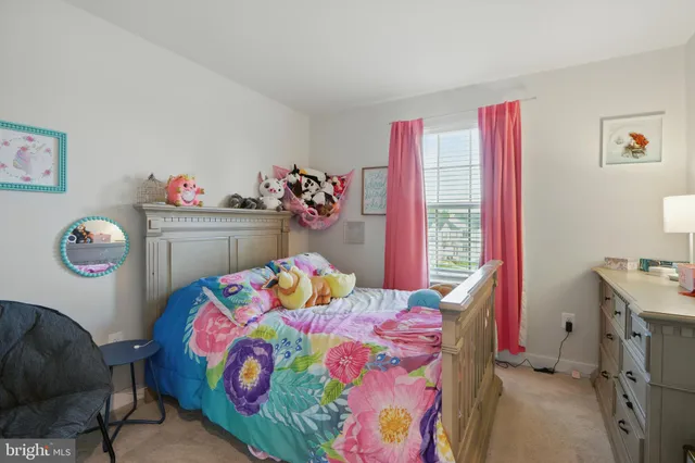 a bedroom with a bed a dresser and next to a window